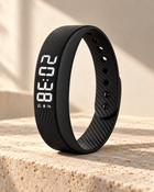 Black WAKE™ bracelet with ribbed silicone strap and illuminated display on warm limestone