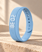 Light Blue WAKE™ bracelet with ribbed silicone strap and illuminated display on warm limestone