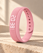 Pink WAKE™ bracelet with ribbed silicone strap and illuminated display on warm limestone